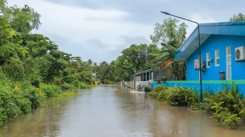 A tropical street in Nolhivaranfaru, Maldives, submerged due to flooding.