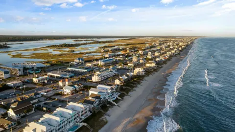 Scenic aerial view of a coastal town with sandy beaches and waves in North Carolina.