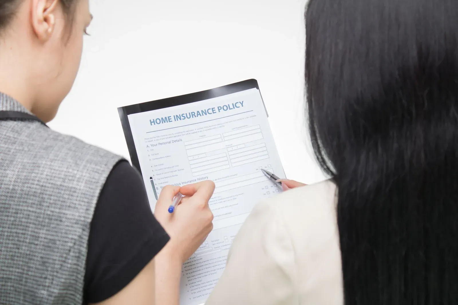 A couple reviewing a home insurance policy document together at a table.