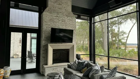 Cozy modern living room in Bluffton, SC featuring a fireplace and outdoor view.