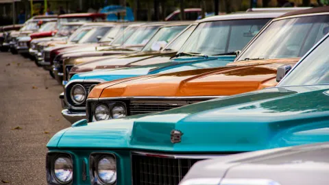 A row of classic vintage cars displayed outdoors. Perfect for car enthusiasts and retro themes.