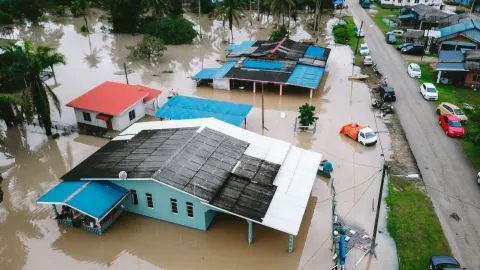 Aerial view of a flooded village in Kijal, Terengganu, Malaysia, showcasing submerged houses and streets.