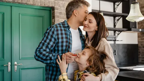 A loving family shares a group hug in their modern kitchen, showcasing warmth and togetherness.